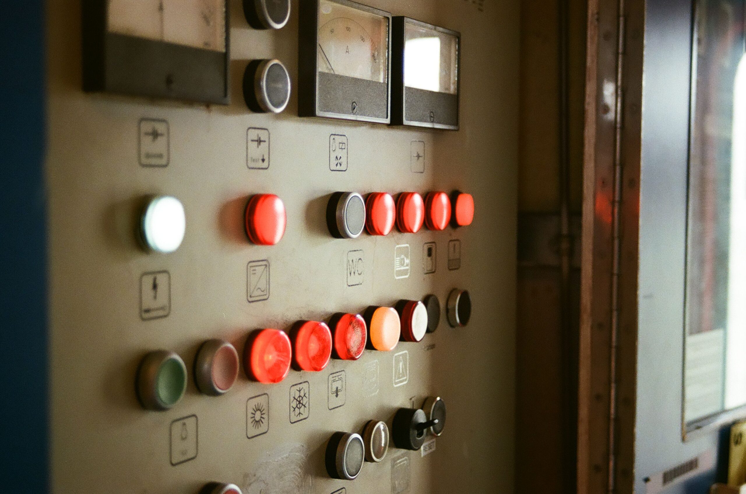 Close-up of a control panel with illuminated buttons and gauges, suggesting industrial technology.